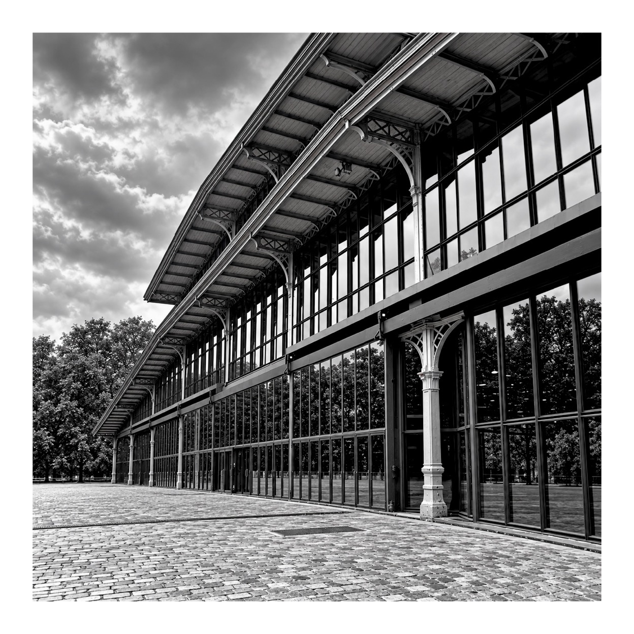 La façade du Grand Hall de la Villette, ses verrières et sa structure métallique en noir et blanc.
